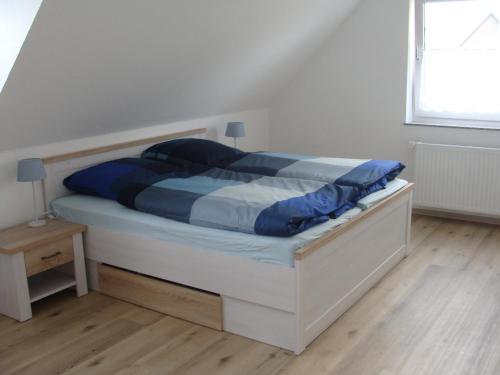 a bedroom with a bed with blue sheets and a window at Ferienhaus Landblick in Geldern