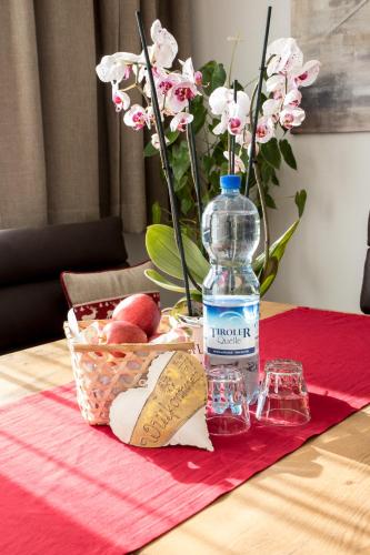 eine Flasche Wasser und ein Obstkorb auf dem Tisch in der Unterkunft Alpenperle in Obsteig