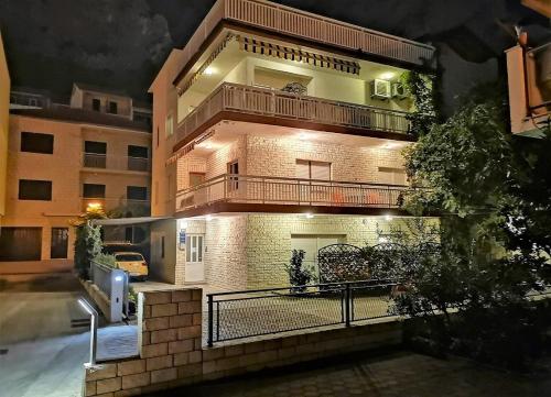 a brick building with a balcony on the side of it at Apartments Neven in Omiš