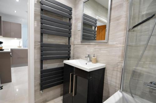 a bathroom with a sink and a shower at City Centre living in High Wycombe