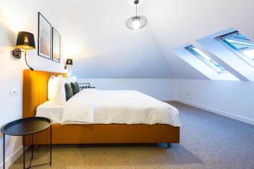 a bedroom with a bed and a table in a attic at UpperHouse Suites & More in Braşov