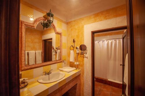 a bathroom with a sink and a mirror and a shower at Hotel Palacio de Doña Beatriz in Antigua Guatemala