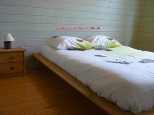 ein Bett mit weißer Bettwäsche und Kissen darauf in der Unterkunft Heartwood in Arbonne