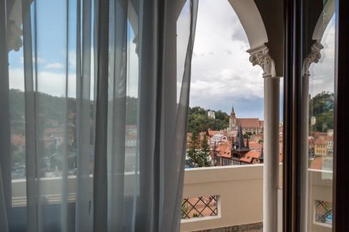 a window with a view of a city at UpperHouse Suites & More in Braşov
