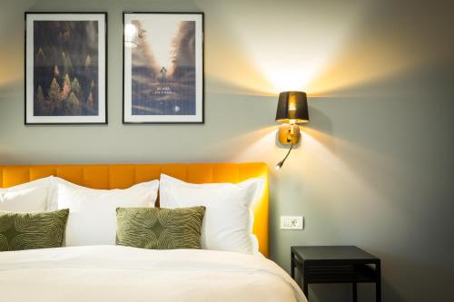 a bedroom with a bed and two pictures on the wall at UpperHouse Suites & More in Braşov