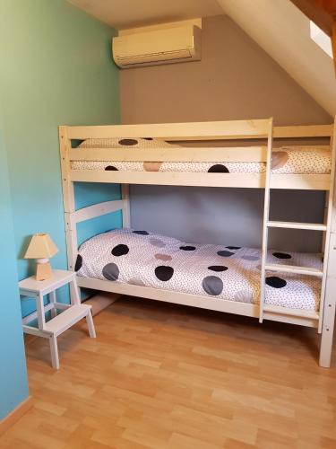 Cette chambre dispose de lits superposés avec 2 lits superposés et une table. dans l'établissement Maison, 5km de la mer, à Fontaine-Henry
