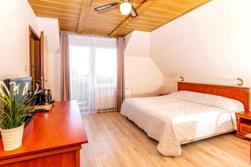 a bedroom with a bed and a desk and a window at Rades in Władysławowo
