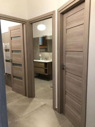a bathroom with two wooden doors and a sink at casa Fantulìn Mare in Laigueglia