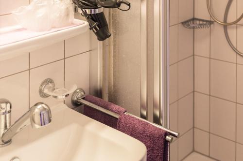a bathroom with a sink and a shower with purple towels at Haus Bärbel in Geisfeld