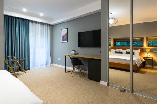 a hotel room with a bed and a desk at UpperHouse Suites & More in Braşov