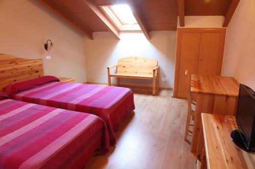 a room with two beds and a table and a television at hotel rural la gavilla in Villanueva de los Infantes