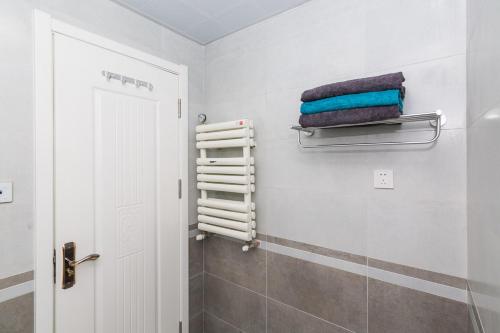 a bathroom with a towel rack and a shower at Qingdao Shibei·Kaide Mall· Locals Apartment 00151110 in Qingdao