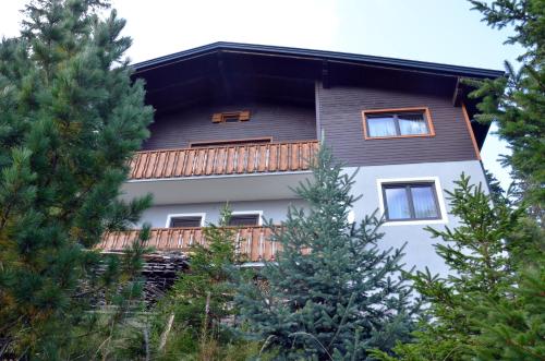 a house with a balcony with trees in the foreground at Ferienhaus Bergfee in Klippitztorl