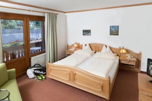 Schlafzimmer mit einem Bett, einem Schreibtisch und einem Fenster in der Unterkunft Hotel Laserz in Lienz