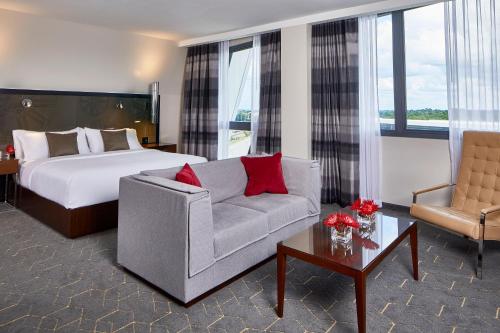 アトランタにあるKimpton Overland Hotel - Atlanta Airport, an IHG Hotelのベッドとソファ付きのホテルルーム