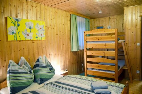 a bedroom with a bed and a wooden wall at Ferienhaus Bergfee in Klippitztorl