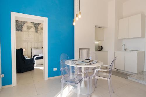una sala da pranzo con tavolo e sedie bianchi di Relais Mareluna - Luxury Apartments a Salerno