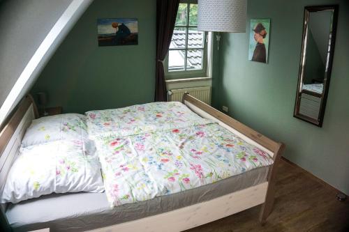 a bed in a bedroom with green walls at Ferienwohnung Worpsweder Schlösschen in Worpswede