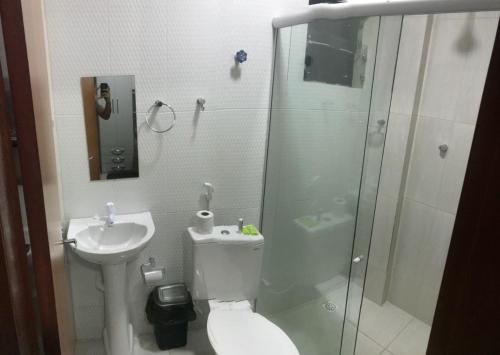 a bathroom with a shower and a toilet and a sink at Sâmily Hotel in Currais Novos