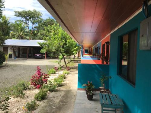 a colorful building with a bench and plants on it at Cabinas Surf Side in Cahuita