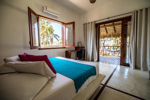 a bedroom with a bed and a couch and a window at Pousada Vayú in Icaraí