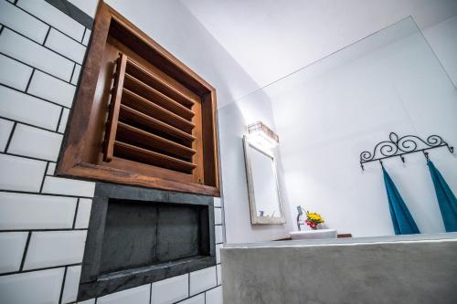 a bathroom with a fireplace and a mirror at Pousada Vayú in Icaraí
