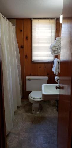 La salle de bains est pourvue de toilettes, d'un lavabo et d'une fenêtre. dans l'établissement Caribou Lodge and Motel, à Soda Springs