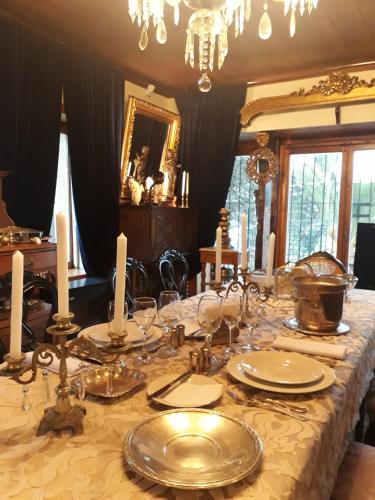 a table with silver plates and candles on it at A Hotel Boutique Pelluhue in Pelluhue