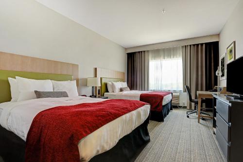 a hotel room with two beds and a desk at Country Inn & Suites by Radisson Houston Westchase-Westheimer in Houston