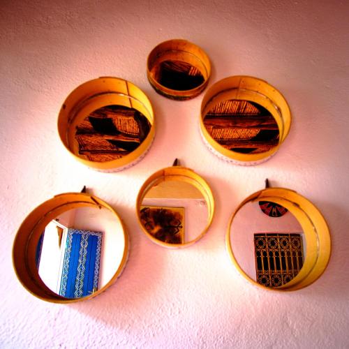 a group of four mirrors on a wall at Auberge Ayouze in Aït Ben Haddou