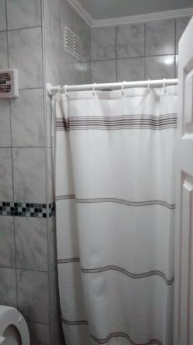 a bathroom with a shower and a toilet at Casa Huespedes Angoba in Arica