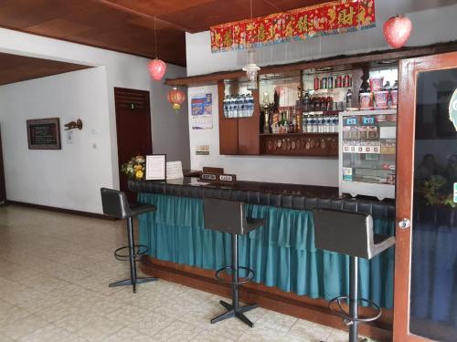 a bar in a restaurant with a counter and stools at Hotel Olibert Parapat Ajibata Mitra RedDoorz in Parapat