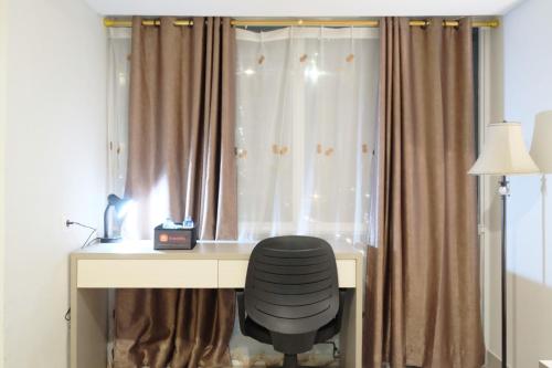 a desk with a chair in front of a window at Best Price Spacious Studio Apartment at H Residence near MT Haryono By Travelio in Jakarta