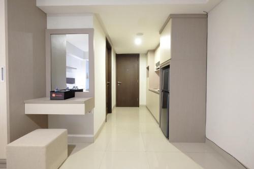a hallway of a kitchen with a counter and a mirror at Best Price Spacious Studio Apartment at H Residence near MT Haryono By Travelio in Jakarta