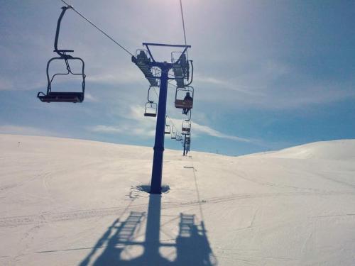 a ski lift in the middle of a snow covered field at Villa Winterfell Popova Shapka in Popova Shapka
