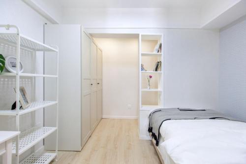 - une chambre blanche avec un lit et des étagères blanches dans l'établissement Wuhan Wuchang·Hualin Huabu Lane· Locals Apartment 00142780, à Wuhan
