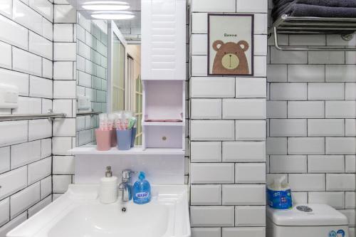 La salle de bains est pourvue d'un lavabo et d'un mur carrelé. dans l'établissement Wuhan Wuchang·Hualin Huabu Lane· Locals Apartment 00142780, à Wuhan