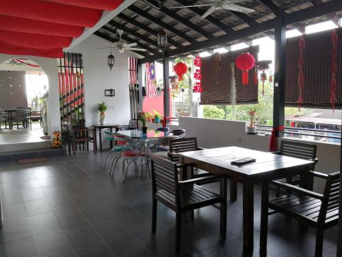 ein Restaurant mit Tischen und Stühlen und roten Dekorationen in der Unterkunft Millenium maison home in Alor Setar