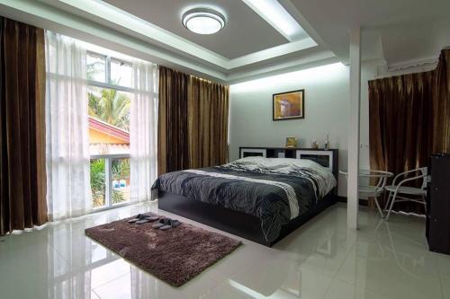um quarto com uma cama e uma grande janela em Napakarn Homestay em Chiang Rai