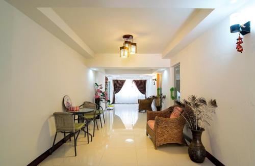 uma sala de estar com um sofá, cadeiras e uma mesa em Napakarn Homestay em Chiang Rai