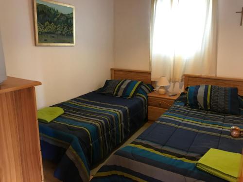 a bedroom with two beds and a window at Cabañas Parador del Aguila - Lago Vichuquén in Vichuquén
