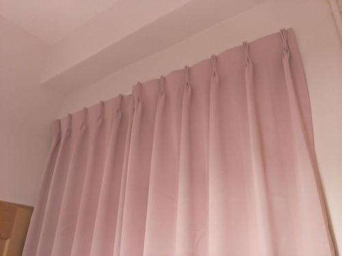 a curtain in a room with pink curtains at MILU Backpacker Hostel in Puli