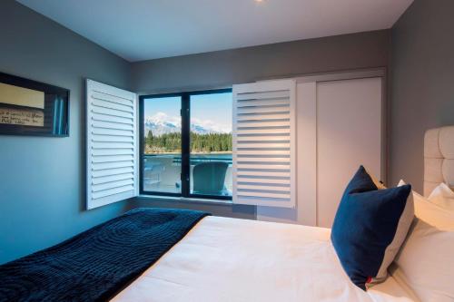a bedroom with a bed and a window with a view at 21 Lakefront by Amazing Accom in Queenstown