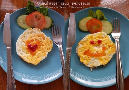 dois pratos de café da manhã com ovos e frutas sobre uma mesa em Pueanjai Resort and Restaurant em Chumphon