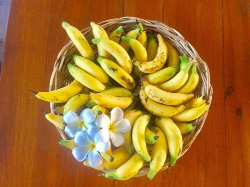 um cesto de bananas e flores sobre uma mesa em Pueanjai Resort and Restaurant em Chumphon