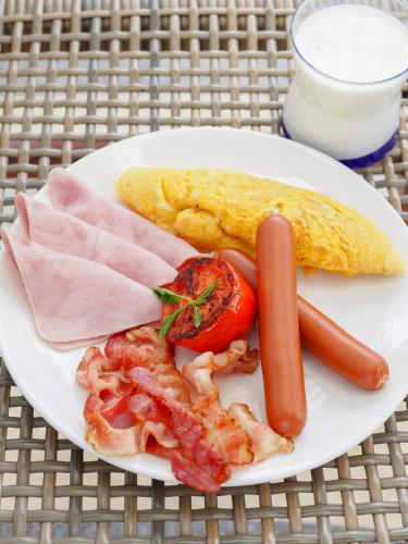 um prato de comida com uma salsicha e outros alimentos em Saai Resort em Bang Saphan Noi