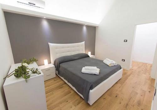 una camera da letto con un letto e due asciugamani di Manganelli Home a Catania