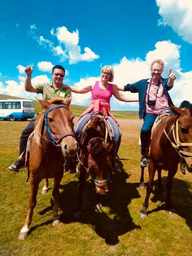 a group of people riding horses in a field at Lemongo Youth Hostel Hohhot in Hohhot