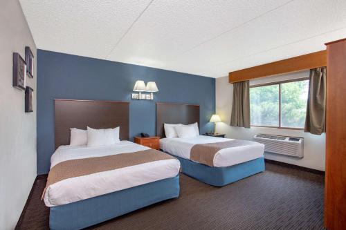 Säng eller sängar i ett rum på AmericInn by Wyndham Green Bay West