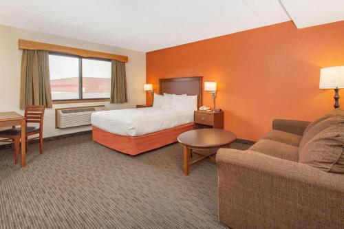 a hotel room with a bed and a couch at AmericInn by Wyndham Calumet in Calumet